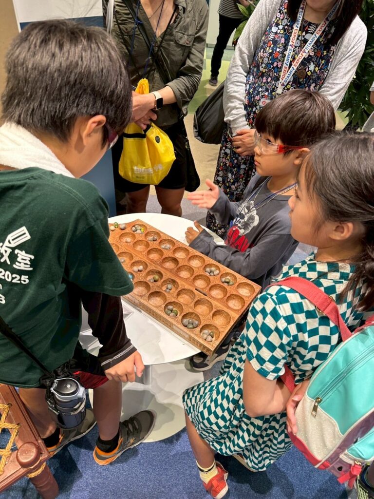 2025年度　日本留学交流プログラム　見学で説明を聞く子供たちと保護者の様子